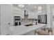 Modern kitchen with stainless steel appliances, white cabinetry, quartz countertops and gold hardware at 574 Loblolly Pl, Auburndale, FL 33823