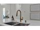 Close up view of kitchen sink, faucet, and quartz countertops with decor at 574 Loblolly Pl, Auburndale, FL 33823