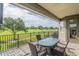 Enjoy the serene golf course view from this balcony, featuring a table and comfortable seating at 7330 Reflections Lake Dr, Lakeland, FL 33813