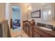 Bathroom featuring double sinks with granite counters and dark wood cabinetry, offering plenty of storage space at 7330 Reflections Lake Dr, Lakeland, FL 33813
