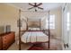 Cozy bedroom featuring a four-poster bed with a vintage-style canopy and neutral decor at 7330 Reflections Lake Dr, Lakeland, FL 33813