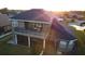 Aerial view of a two-story home showcasing a large patio on the second level and a screened-in porch below at 7330 Reflections Lake Dr, Lakeland, FL 33813
