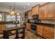 Well-equipped kitchen with stainless steel appliances, wooden cabinets, and black countertops at 7330 Reflections Lake Dr, Lakeland, FL 33813