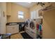 Bright laundry room with modern washer and dryer, granite counters, and built-in cabinets at 7330 Reflections Lake Dr, Lakeland, FL 33813