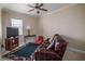 Comfortable living room with a plush leather sofa, television, and a ceiling fan at 7330 Reflections Lake Dr, Lakeland, FL 33813