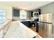 Modern kitchen boasts stainless steel appliances, white marble countertops, and stylish blue cabinetry at 3523 Colleen Dr, Lakeland, FL 33810
