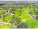 Scenic aerial view of property featuring verdant fields, a winding stream, mature trees, and residential development in the distance at 1096 Drew St, Lakeland, FL 33810