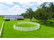 Aerial view of a green grass paddock enclosed by a white fence, accompanied by a barn and grazing horses at 1096 Drew St, Lakeland, FL 33810