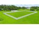 Aerial view of a large green grass paddock surrounded by a white fence with a house in the background at 1096 Drew St, Lakeland, FL 33810