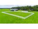 Aerial view of a large green grass paddock surrounded by a white fence and includes a barn structure in the background at 1096 Drew St, Lakeland, FL 33810