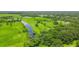 Expansive aerial view showing lush greenery, a winding river, and scattered buildings under a bright sky at 1096 Drew St, Lakeland, FL 33810