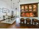 Stylish dining area with a built-in bar, rustic table, and modern lighting at 1323 Hammock Shade Dr, Lakeland, FL 33809