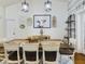 Bright dining room featuring a rustic wood table, modern lighting, and eclectic decor at 1323 Hammock Shade Dr, Lakeland, FL 33809