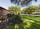 Manicured front yard with lush landscaping, green lawn, mature trees, and shade at 1323 Hammock Shade Dr, Lakeland, FL 33809