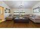 Bright living room featuring a large sectional sofa, hardwood floors, and arched windows at 1323 Hammock Shade Dr, Lakeland, FL 33809