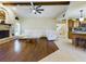Spacious living room with wood floors, brick fireplace, ceiling fan, and white leather sofa at 1323 Hammock Shade Dr, Lakeland, FL 33809