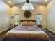 Bright main bedroom with a half moon window, ceiling fan, hardwood floors, and patterned quilt at 1323 Hammock Shade Dr, Lakeland, FL 33809