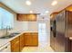 Kitchen with wood cabinets, double sink, and view to the dining area at 1426 Persimmon Way, Lakeland, FL 33811