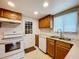 Kitchen features wood cabinets, double sink, and white appliances at 1426 Persimmon Way, Lakeland, FL 33811