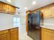 Kitchen with wood cabinets, black refrigerator, and view to patio at 1426 Persimmon Way, Lakeland, FL 33811