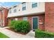 Brick townhouse exterior with green door and landscaping at 1920 E Edgewood Dr # G5, Lakeland, FL 33803