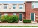 Brick townhouse exterior with green door, landscaping, and walkway at 1920 E Edgewood Dr # G5, Lakeland, FL 33803