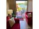 Cozy living room with red sofas and access to a patio with beautiful water views at 1920 E Edgewood Dr # G5, Lakeland, FL 33803