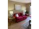 Comfortable living room with a red sofa, decorative art, and access to the patio at 1920 E Edgewood Dr # G5, Lakeland, FL 33803