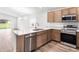 Modern kitchen with stainless steel appliances and light wood cabinets at 631 Bentley North Dr, Auburndale, FL 33823