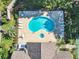 Aerial view of a community pool and tennis court with ample seating and parking at 665 Lake Clark Pl, Lakeland, FL 33813
