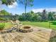 Backyard deck area with fire pit, chairs, and grassy area at 665 Lake Clark Pl, Lakeland, FL 33813