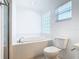 Bright bathroom featuring a soaking tub, a window, and tiled surround at 665 Lake Clark Pl, Lakeland, FL 33813