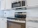 Close up of stainless steel microwave and electric range with granite countertops at 665 Lake Clark Pl, Lakeland, FL 33813