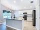 Modern kitchen featuring a granite island, stainless steel appliances, white cabinets, and tiled flooring at 665 Lake Clark Pl, Lakeland, FL 33813