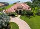 Expansive lakefront home with terracotta roof, lush lawn, and brick drive offers waterfront living at 341 Hamilton Shores Dr. Ne, Winter Haven, FL 33881