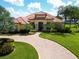 Stunning home boasts a curved brick driveway, lush landscaping, and a vibrant terracotta roof at 341 Hamilton Shores Dr. Ne, Winter Haven, FL 33881