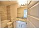 Well-lit bathroom featuring a granite vanity top, tiled shower and tub and tile flooring at 4538 Grandview Glen Dr, Auburndale, FL 33823