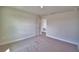 Neutral-colored bedroom with carpet, trim, and an open door that leads to another room at 4538 Grandview Glen Dr, Auburndale, FL 33823