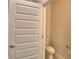 Compact powder room featuring a toilet and door, ideal for guests at 4538 Grandview Glen Dr, Auburndale, FL 33823