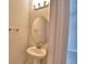 Elegant powder room featuring a stylish pedestal sink and a decorative light fixture at 4538 Grandview Glen Dr, Auburndale, FL 33823