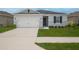 Two-car garage with gray house and landscaping at 296 Spirit Landings Cir, Winter Haven, FL 33880