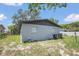 View of the house's rear and backyard, showcasing its simple design and tidy lawn at 602 Taylor Blvd, Winter Haven, FL 33880
