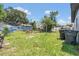 Fenced backyard with shed, grass lawn, and garbage cans, perfect for outdoor activities and storage at 602 Taylor Blvd, Winter Haven, FL 33880
