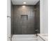 Modern bath and shower featuring gorgeous dark gray tile and a built in shelf at 1918 Dr Martin L King Jr Way, Haines City, FL 33844