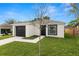 Charming one-story home with a black garage door, modern exterior paint and manicured lawn at 1918 Dr Martin L King Jr Way, Haines City, FL 33844