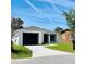 Charming single story home with a black garage door, manicured lawn, and bright sky at 1918 Dr Martin L King Jr Way, Haines City, FL 33844