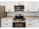 Modern kitchen featuring stainless steel appliances, granite countertops, and stylish white cabinetry at 1918 Dr Martin L King Jr Way, Haines City, FL 33844