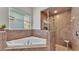 Bathroom with tiled shower, tub, and window at 6857 Eagle Ridge Loop, Lakeland, FL 33813