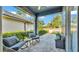 Cozy covered patio with stone pavers, gray rocking chairs, and lush landscaping at 6857 Eagle Ridge Loop, Lakeland, FL 33813