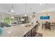 Open kitchen with a large island, granite countertops, dining area, and a view of the living room at 1001 Lena Run Ct, Winter Haven, FL 33880